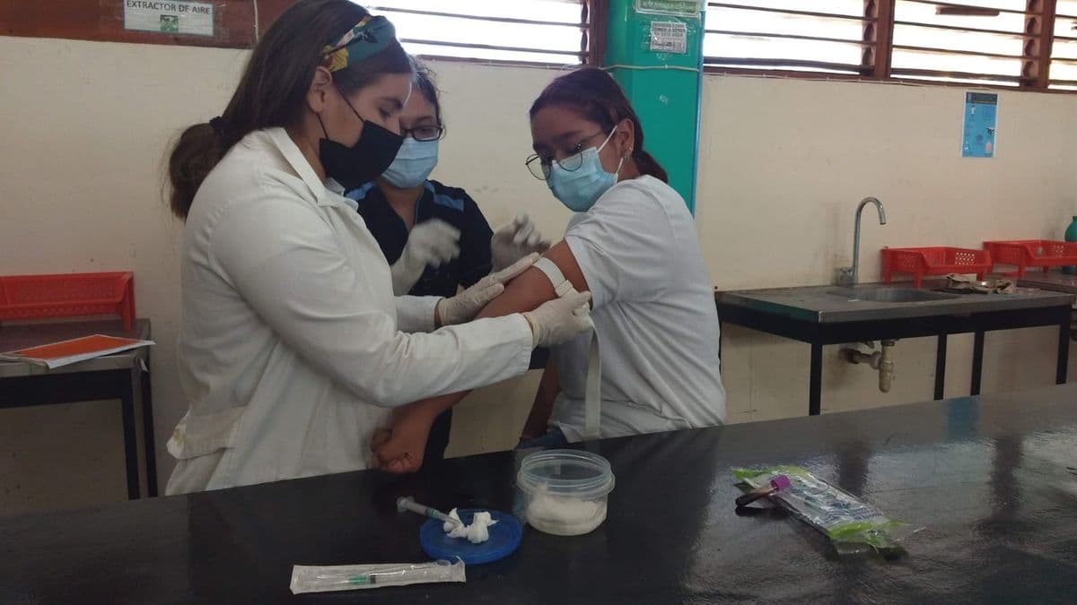 Estudiantes con bata durante una práctica de análisis clínicos