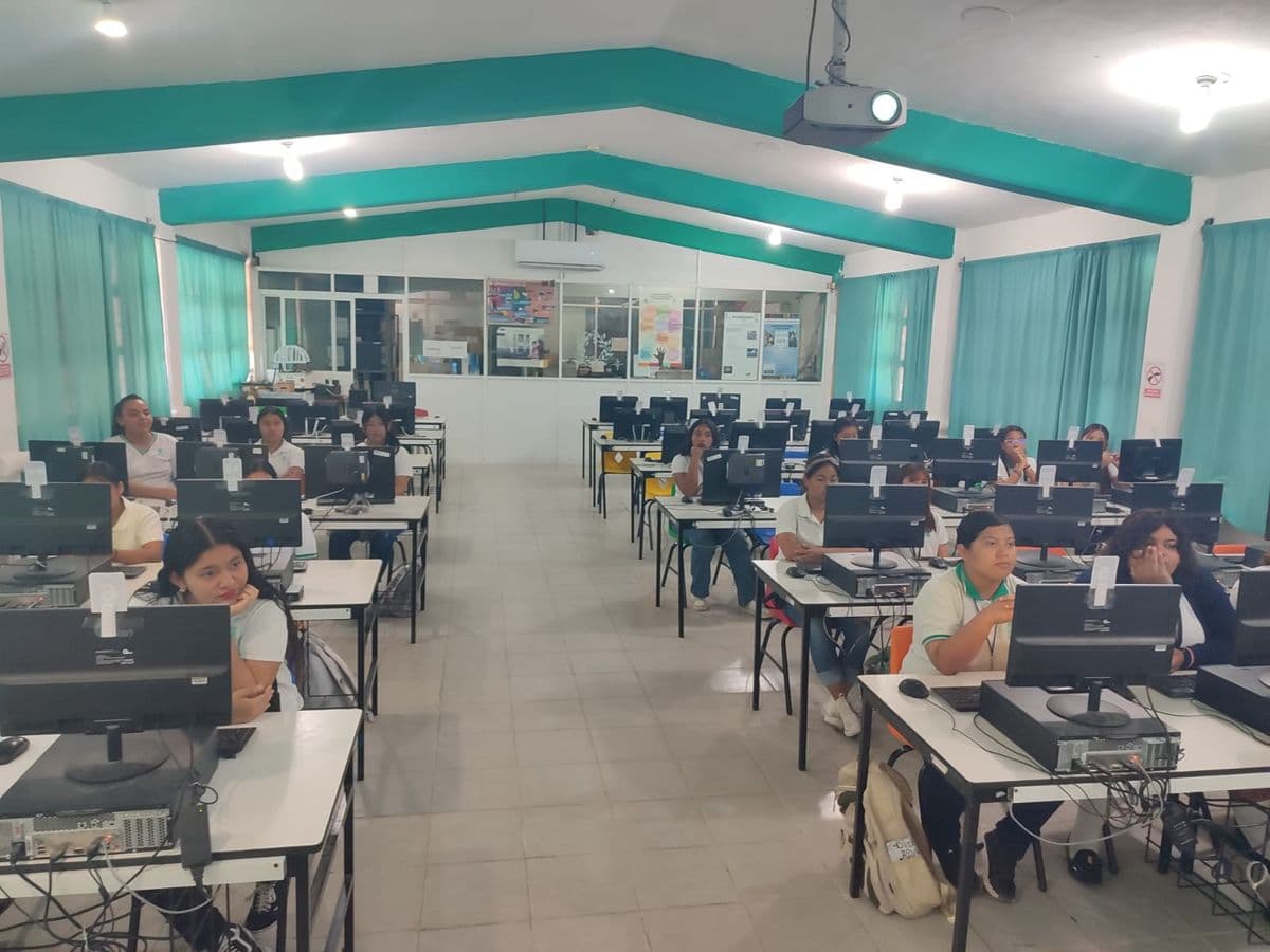 Estudiantes trabajando en computadoras en la sala de cómputo