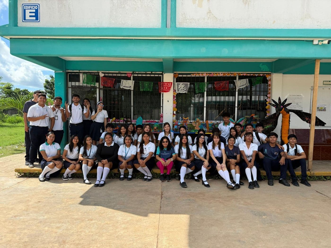 Grupo de estudiantes del plantel reunidos frente al edificio