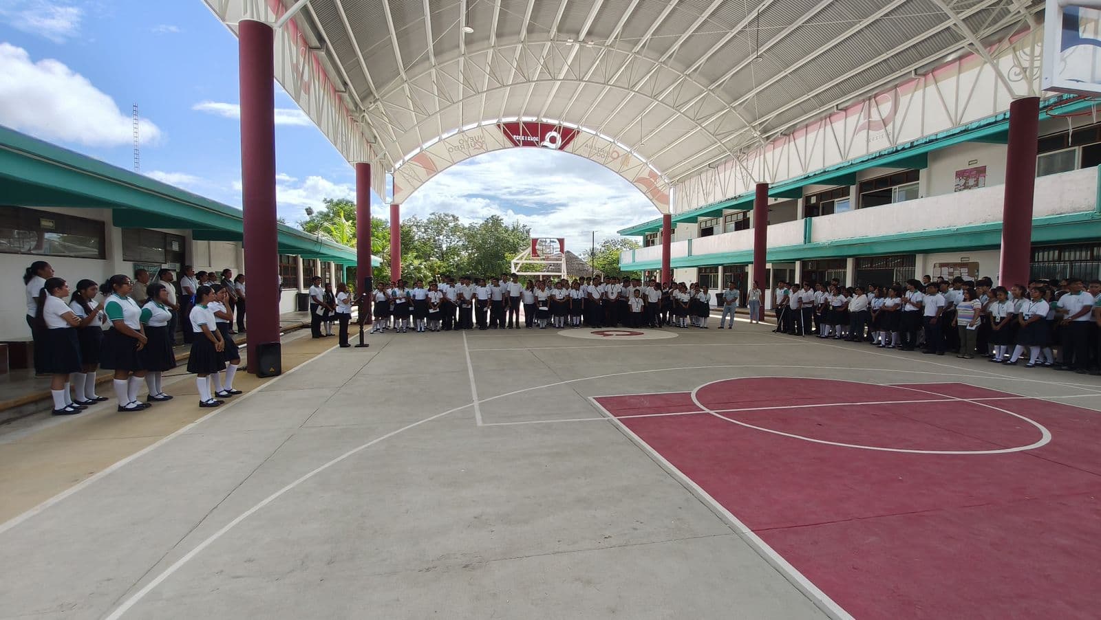 Nuevo domo con techo en arco y cancha de básquetbol, con la comunidad estudiantil formada a los lados