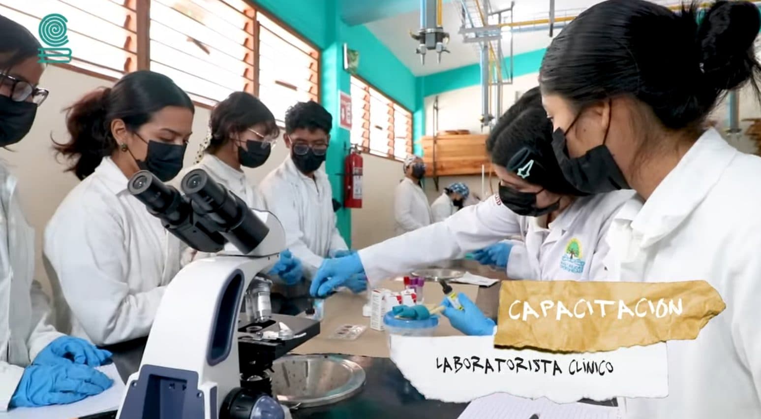 Estudiantes con bata observando muestras en microscopios